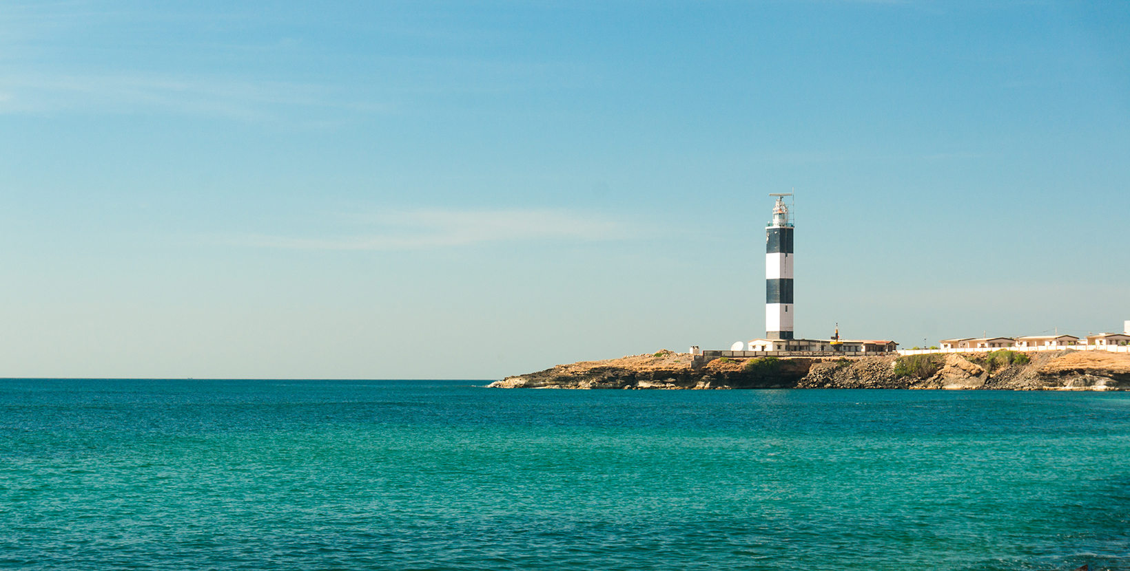 Lighthouse and wave breakers on the coast of the beautiful blue arabian sea in dwarka gujarat india. This highly religious and holy place is one of the most sacred places in hinduism. It also offers