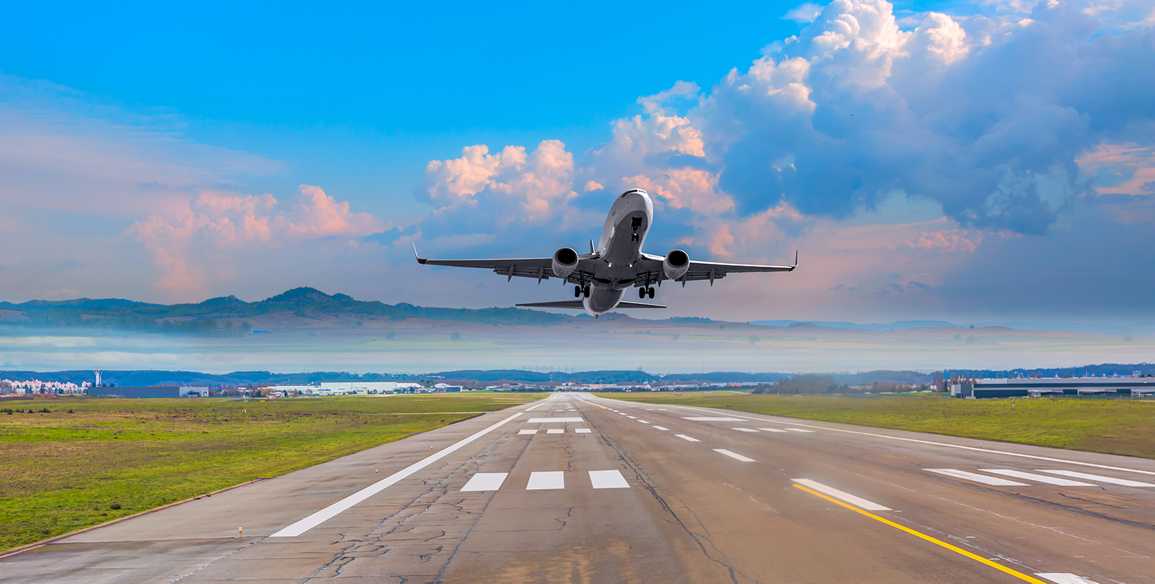 White Passenger plane fly up over take-off runway from airport 