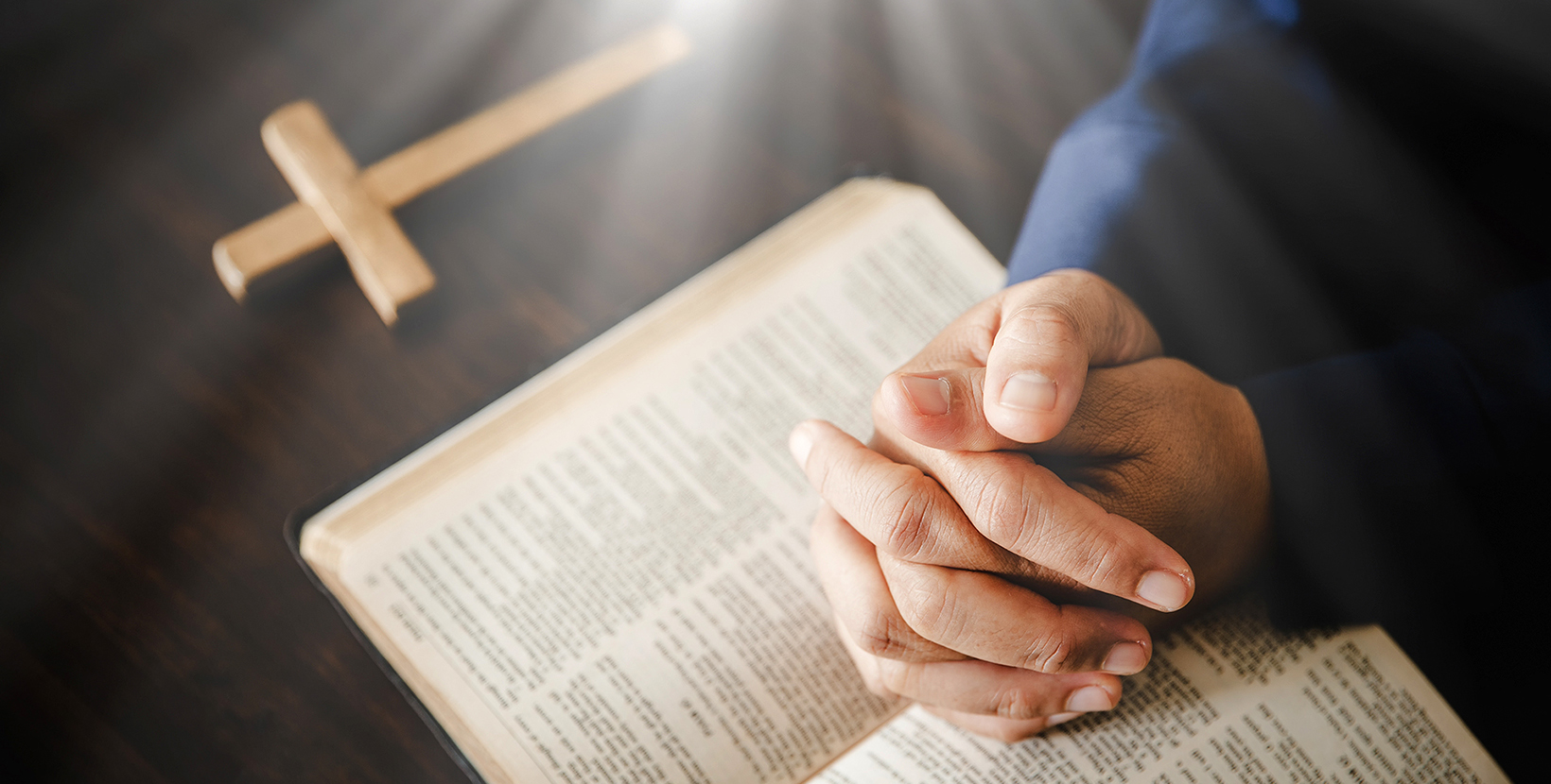 Hand folded in prayer to god on Holy Bible book in church concept for faith, spirituality and religion, woman person praying on holy bible in morning. christian catholic woman hand with Bible worship.