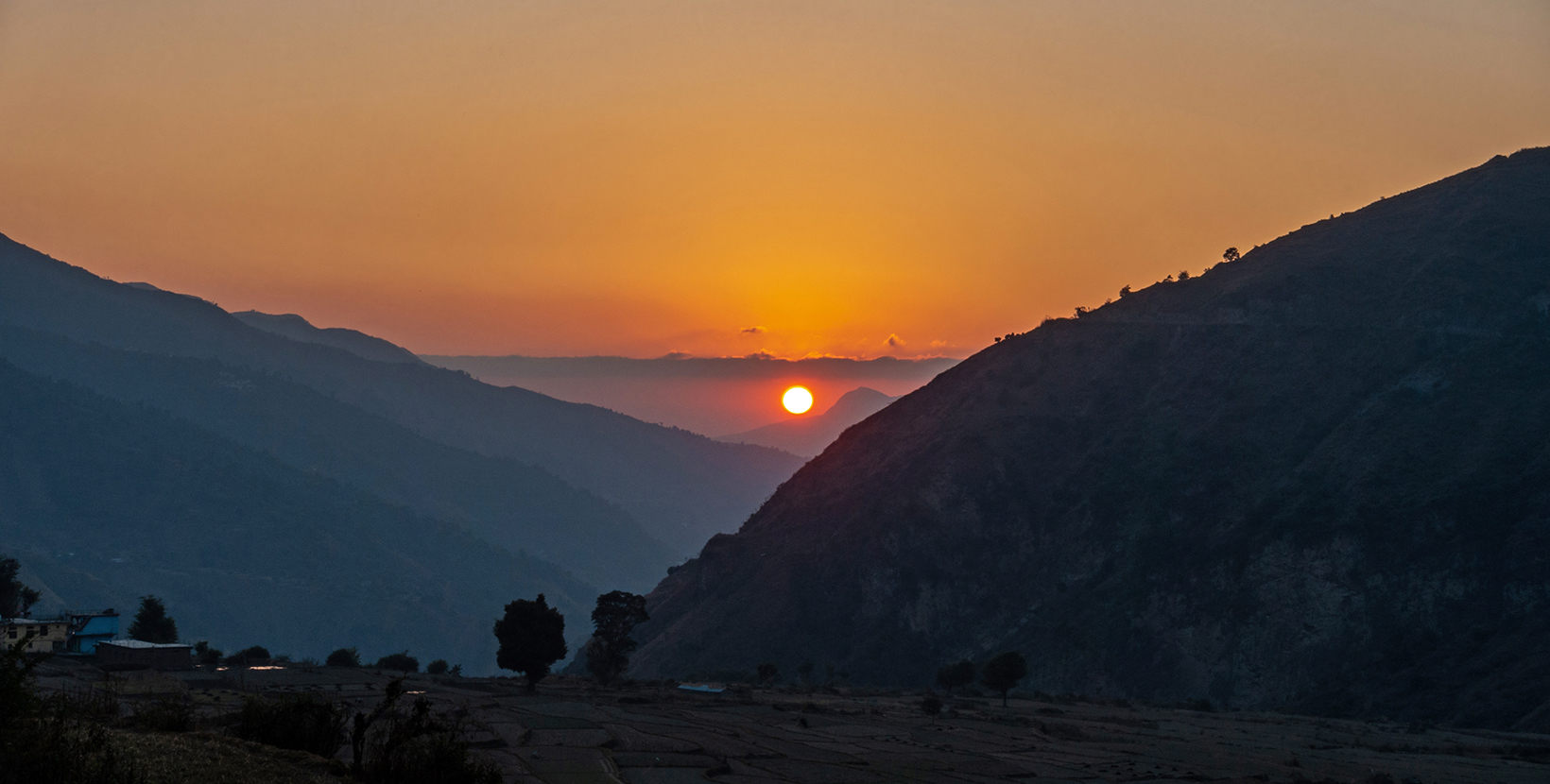 Gorgeous golden hour sunset in Uttarakhand's Himalayan Nag Tibba, featuring a round sun at its center