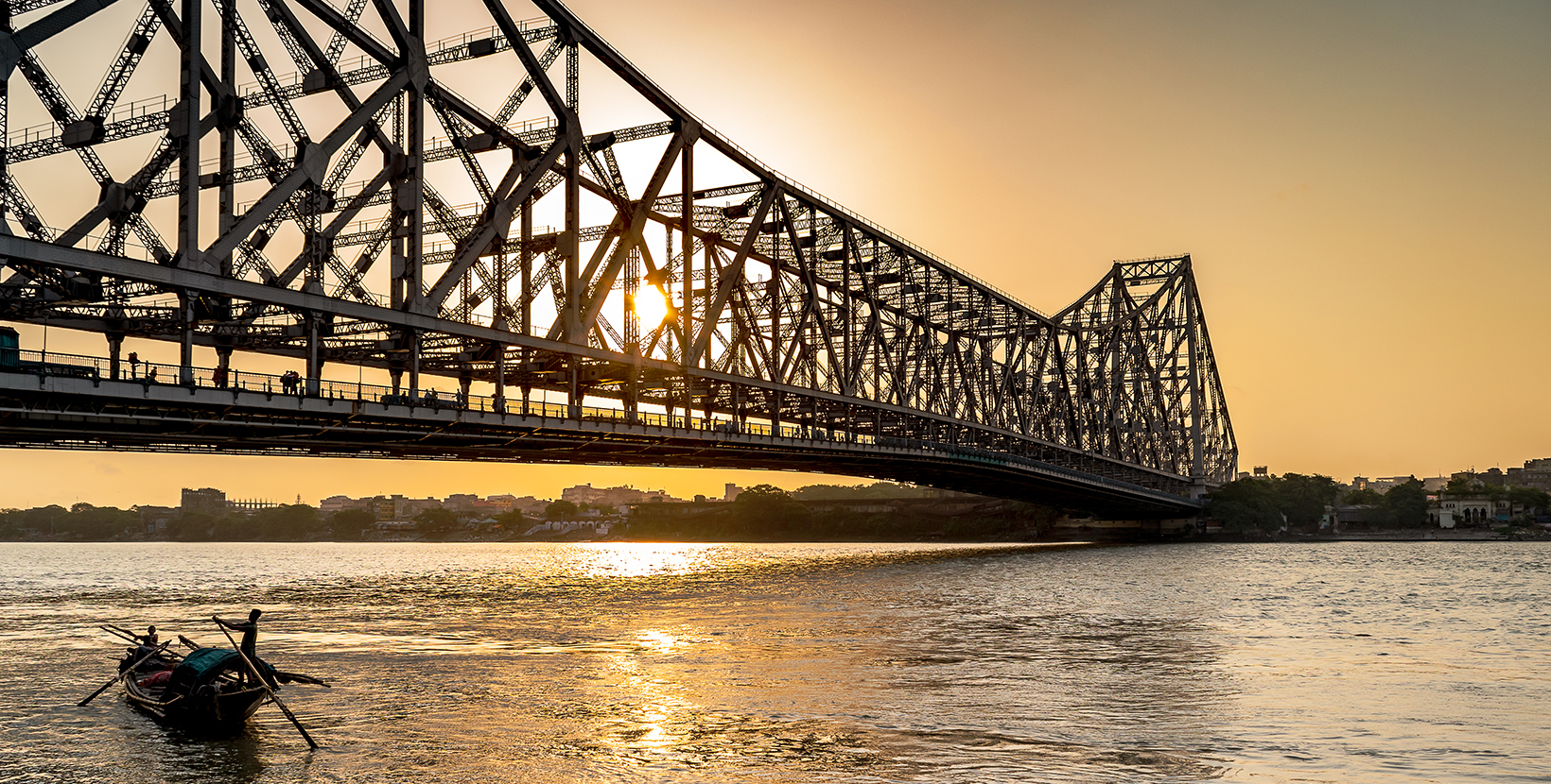 Silhouette of Howrah Bridge at the time of Sunrise.  Howrah Bridge is a bridge with a suspended span over the Hooghly River in West Bengal.; Shutterstock ID 1115425226; purchase_order: -; job: -; client: -; other: -